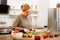 Concentrated mature woman getting dinner ready on wooden table