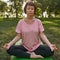 Concentrated mature woman practicing yoga in park