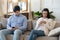 Concentrated millennial couple internet addiction victims using gadgets at home