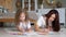 Concentrated mother and preschooler daughter draw on papers