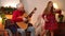 Concentrated positive grey-haired grandfather playing guitar as joyful teenage granddaughter singing dancing at