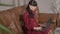 Concentrated pregnant Caucasian woman typing on laptop keyboard sitting on couch at home. Portrait of busy confident