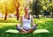 Concentrated pregnant yogini relaxing in park