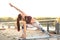 Concentrated pretty strong young redhead sports woman make yoga exercise outdoors