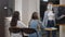 Concentrated schoolgirls in Covid face masks listening to teacher explaining lesson and raising hands to answer question