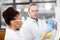 Concentrated scientists analyzing test tube in laboratory