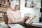 Concentrated senior female person reading her book