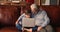 Concentrated small boy using computer application with old grandfather.