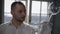 Concentrated sommelier waiter checking cleanliness of drinking glass in sunlight standing at window in restaurant