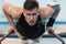 Concentrated sportsman exercising on parallel bars and looking at camera