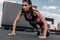 concentrated sportswoman doing push up on asphalt