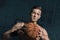 Concentrated sporty man holding basketball ball in hands