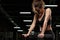 Concentrated strong sports lady sitting in gym