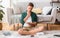 Concentrated teen boy sitting on floor at room, reading book