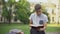 Concentrated teenager reading book in park on bench, preparing for exams