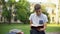 Concentrated teenager reading book in park on bench, preparing for exams