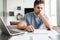 Concentrated tired man working with papers at home