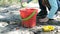 Concentrated toddler playing with his toy bucket and shovel near the river. Springtime and early morning. Investigate  details of