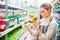 Concentrated woman choosing agricultural chemicals for flowers and plants