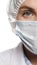 Concentrated woman doctor in surgical mask looking at camera, behind clean white bright background. Medical practitioner
