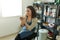 Concentrated woman painting clay jug with colourful paint shaping and sculpturing earthenware cup in pottery studio on