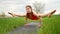 Concentrated woman in tittibhasana doing yoga practice in green field. Strong lady, sport, peaceful mind, practice on