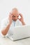 Concentrated worried casual man using laptop at desk