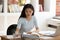 Concentrated young Asian female student sitting at desk in library.