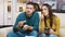 Concentrated young couple sitting on couch eating fried chicken