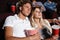 Concentrated young friends loving couple sitting in cinema