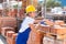 Concentrated young girl worker in a warehouse is laying bricks