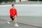 Concentrated young man in casual clothes doing warm-up before workout with serious face looking away. Athletic guy trains on the