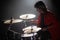 Concentrated young man playing drum set at concert