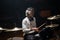 Concentrated young man training on drum set in studio