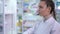 Concentrated young woman gathering pills for order in pharmacy indoors. Side view portrait of Caucasian drugstore