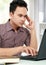 Concentrating man working with laptop at his desk