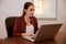 Concentrating young woman typing in laptop