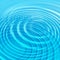 Concentric water ripples blue background