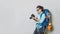 Concep image of a girl with a backpack in a handheld camera on a white background. travel backpack. Travel around the world