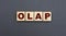 Concept acronym OLAP on wooden cubes on a gray background