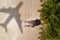 Concept of airplane travel to exotic destination with shadow of commercial airplane flying above beautiful tropical beach. Beach