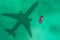 Concept of airplane travel to exotic destination with shadow of commercial airplane flying above beautiful tropical beach. Beach