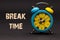 Concept,alarm clock with break time phrase written on black back