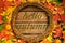 The concept of autumn wallpaper. Dried maple leaves and acorns lined with a round frame with text: Hello autumn.