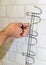 Concept of bathroom remodeling. installation of hanger, towel holder with a screwdriver