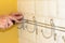 Concept of bathroom remodeling. installation of hanger, towel holder with a screwdriver