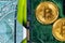 Concept of Bitcoin Mining. A little miner is digging for bitcoin with graphic card dollars. Golden Bitcoin on the green microchip