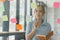 The concept of brainstorming is exemplified as a millennial Asian businesswoman shares ideas using sticky notes, which