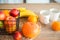 Concept breakfast made from fruits and coffee or tea. Oranges, bananas, cups, peaches on a textural large wooden table against a b