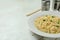 Concept of breakfast with plate of noodles on white textured background